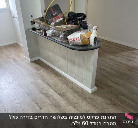 רצפת פרקט עץ בהירה בחדר עם קיר לבן